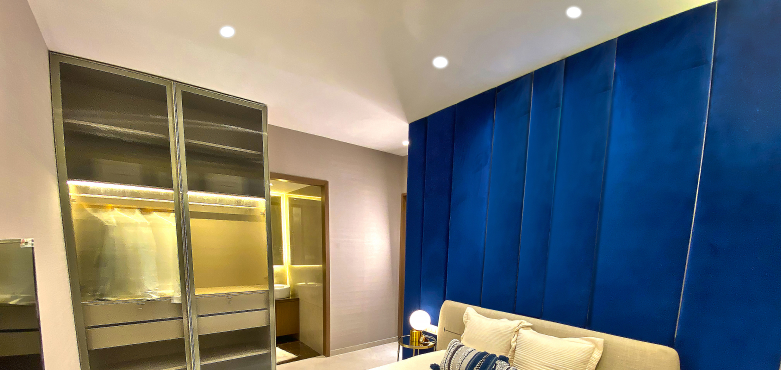 Scenic deck with two people relaxing by a lily pond and lush trees reflecting living in 2 BHK in Thane at Runwal Lands now!